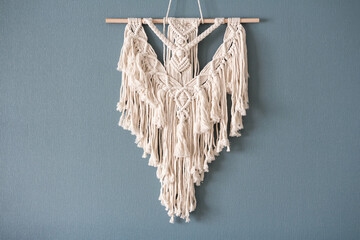 Wall Mural - Macrame. Handmade macrame weaving and cotton threads on a rustic wooden stick. Scandinavian style in the interior, boho style. Cozy home.