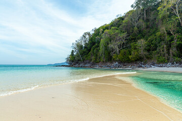 Soft blue ocean wave on clean sandy beach
