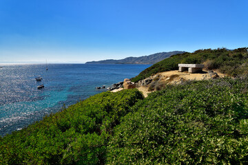 Stone bench with amazing view of pure clear azure coast near the Spiaggia di Mari Pintau beach in Sardinia, Sardinia, Italy.