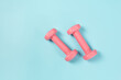 © zhikun sun - Two pink dumbbells isolated on blue background
