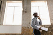 © Tetra Images - Young interior designer looking at new office space