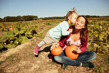 Mother And Daughter In Pumpkin Field