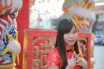 Wall Mural - beauty woman wear red cheongsam looking and smile in chinese new year