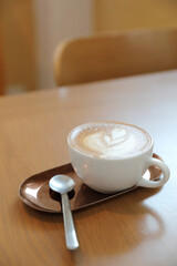 Wall Mural - cappuccino or Latte art coffee made from milk on the wood table in coffee shop