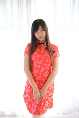 Wall Mural - beauty woman wear red cheongsam looking and smile in chinese new year