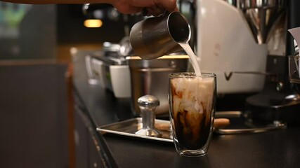 Sticker - Barista pouring milk into a glass of iced coffee