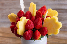 A View Of A Bouquet Of Fruit, Featuring Pineapple Flowers And Strawberries.