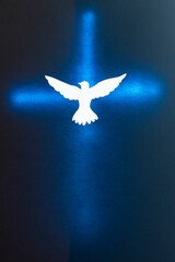 White Dove silhouette over a shining cross.