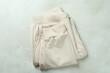 Folded sweatpants on white textured background, top view