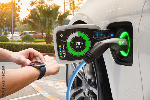 Electric vehicle changing on street parking with graphical user interface synchronize with smart watch, Future EV car concept