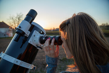 Wall Mural - woman looking at night sky with amateur astronomical telescope.