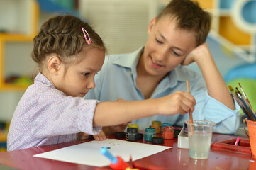 Wall Mural - Smiling brother and sister drawing together