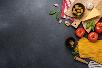 Wall Mural - Italian cuisine black background. Red tomatoes, spaghetti, olives, basil, olive oil, garlic top view. Ingredients for cooking pasta with tomato sauce. Mediterranean  food background