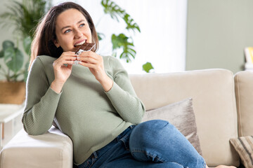 Wall Mural - Woman biting a chocolate bar