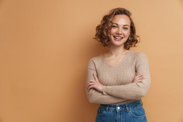 Wall Mural - Young ginger woman with wavy hair smiling and looking at camera