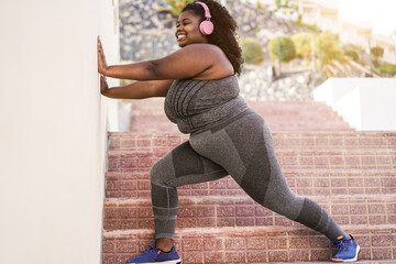 Wall Mural - Curvy african girl doing sport workout routine outdoor in the city - Focus on face