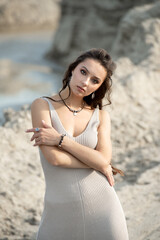 Wall Mural - portrait of young sexy tanned beautiful woman standing on sand near the sea