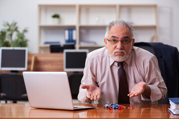 Sticker - Old male employee in gambling concept at workplace