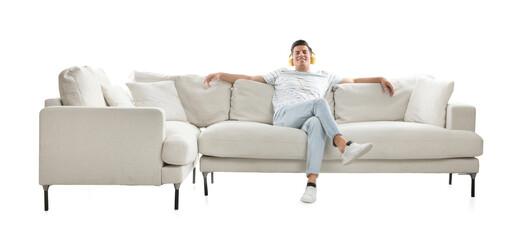 Canvas Print - Man listening to music on comfortable sofa against white background