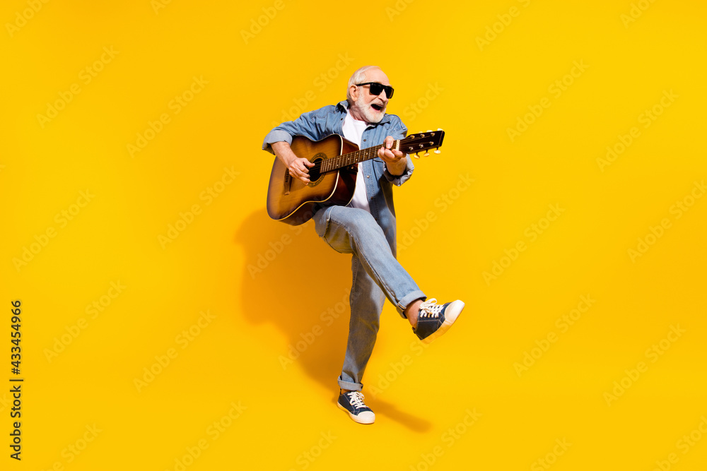 Full length photo of cool happy positive old man dance hold guitar wear sunglass isolated on yellow color background - obrazy, fototapety, plakaty 