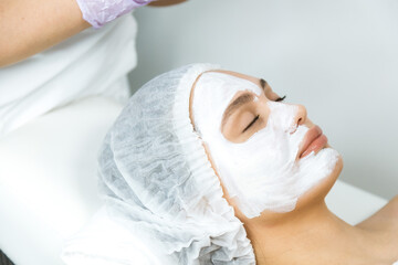 Wall Mural - Facial skin care and protection. A young woman at a beauticians appointment. Portrait of a woman with a rejuvenating face mask