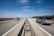 © Margo Ladygina - Country road with moving cars against the blue sky