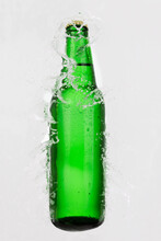 Green Bottle Of Beer In Water Splash