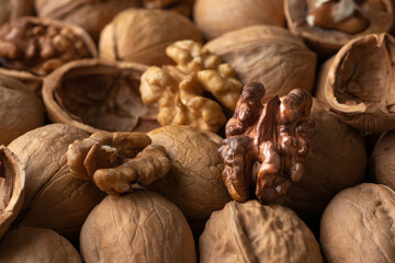 Tasty unshelled walnuts on heap of nuts. Close up view