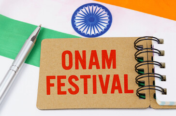 Against the background of the flag of India lies cardboard with the inscription - Onam Festival