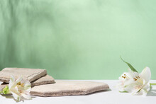 Background For Cosmetic Products Of Natural Green Color. Stone Podium With White Flowers. Front View.