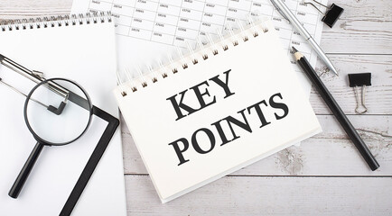 Poster - Notepad with text KEY POINTS with a pen,office tools and graphs on the desktop.