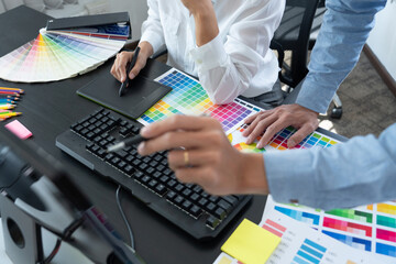 Poster - graphic designer or creative working together coloring using graphics tablet and a stylus at desk wi