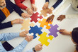 © Studio Romantic - Closeup diverse multinational associates teammate people group moving puzzle pieces on office table for searching and finding solution. Team building, teamwork, collaboration and support concept