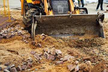 A bulldozer clears the area for the construction of a new, pedestrian road. Close-up