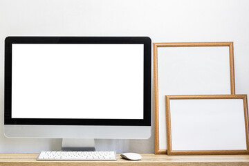 A mock up computer device on table with photo frames.