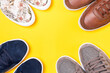 Four pairs of new stylish shoes on a yellow background. Flat lay. Copy space. Close up of shoes toes