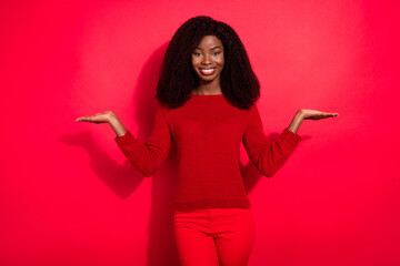 Sticker - Photo of young black girl happy positive smile hold hands balance advert scales solution offer isolated over red color background