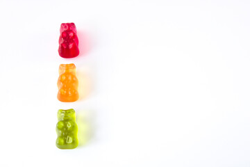 three gummy bears in colours of traffic lights lined up vertically, isolated on white background wit