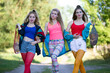 Three beautiful country girls dressed in the style of the nineties are walking along the road.