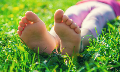 Child feet on the grass. Selective focus.