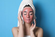 © New Africa - Woman with pomegranate face mask on light blue background