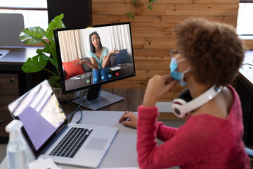 Poster - Businesswoman wearing face mask, sitting at desk using computer having video call
