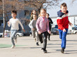 © JackF - Large group of playful children running together at urban landscape