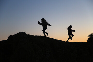 silhouettes of people in the mountain with sunrise sky background