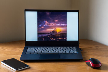 Wall Mural - Laptop on wooden table with a mouse and a mobile phone