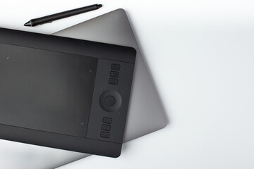 Wall Mural - Top view photo of a graphic design tablet and laptop on a white background.