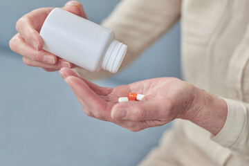 Wall Mural - Senior woman taking daily medications at home during illness