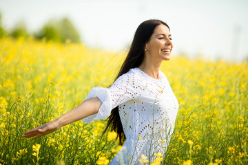 Wall Mural - Young woman in the rapeseed field