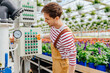 © Iryna - Handsome male experienced plantation worker in overalls equipment with pipelines in modern greenhouse with plants and flowers. Glasshouse pipe heating system