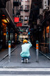 © Alex Bascuas/ADDICTIVE STOCK - Back view of unrecognizable man in casual outfit squatting on pavement while taking photo of urban buildings on camera
